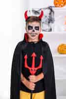 Free photo young boy with devil horns posing for halloween