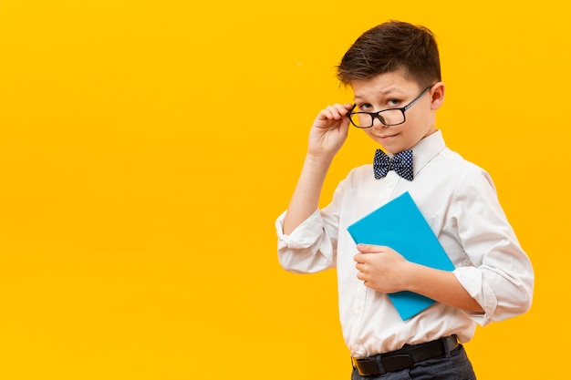 Free photo young boy with glasses holding book