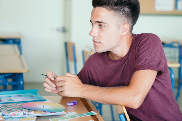 Young boy with school materials in class