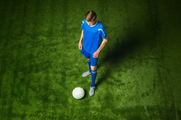 Young boy with soccer ball doing flying kick