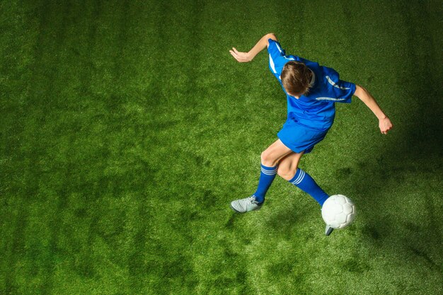 Young boy with soccer ball doing flying kick