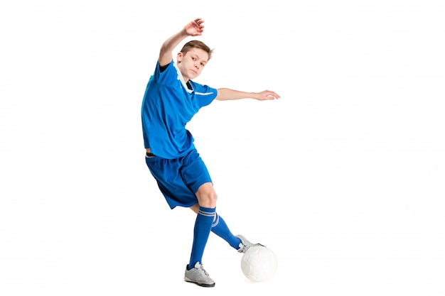 Young boy with soccer ball doing flying kick