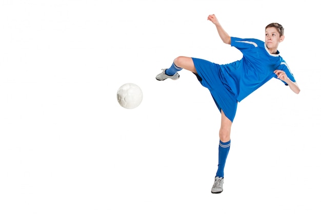 Free photo young boy with soccer ball doing flying kick