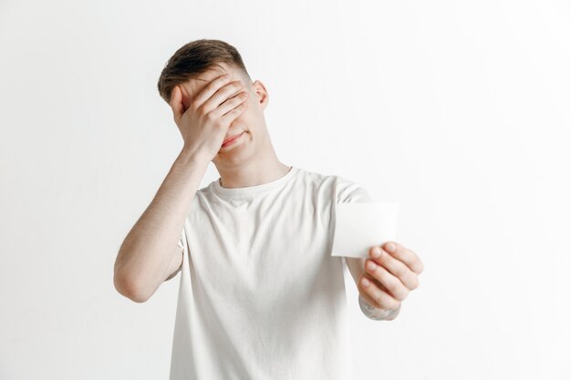 Young boy with a surprised unhappy failure expression bet slip on studio