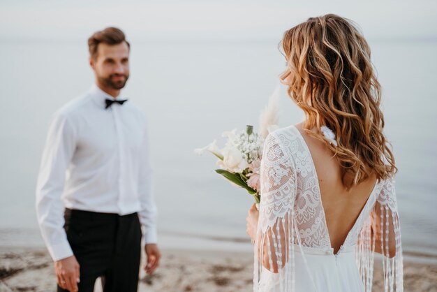 Giovani sposi che hanno un matrimonio sulla spiaggia