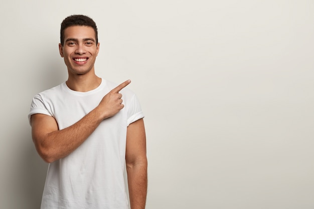 Free photo young brunet man wearing white t-shirt