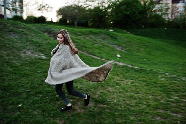 Young brunette girl on plaid having fun at evening spring day