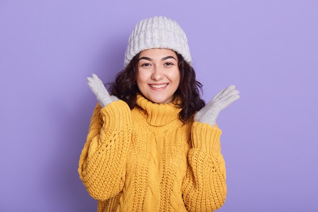 Young brunette girl with cute smile spreading palms aside