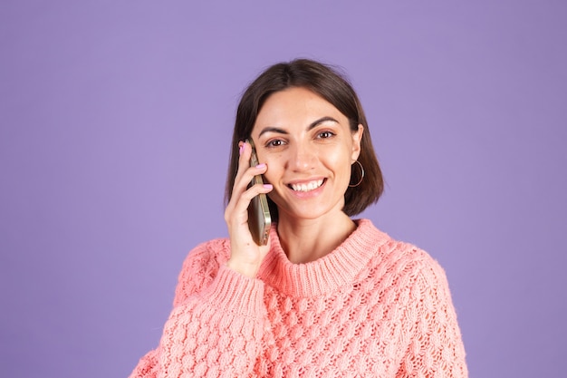 Young brunette isolated on purple wall