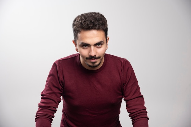 A young brunette man standing and posing