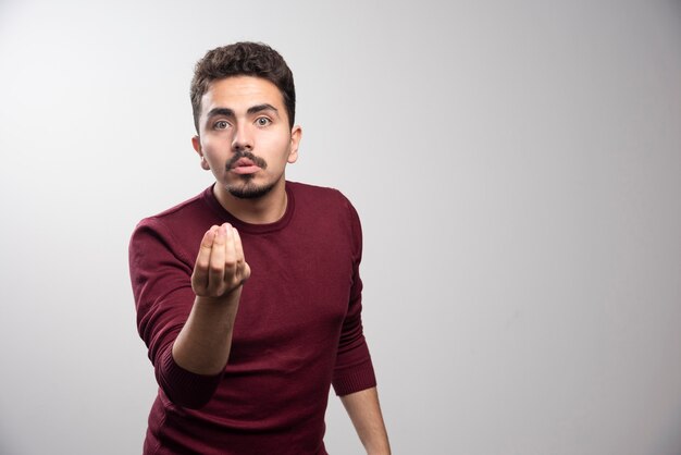 A young brunette man standing and posing .