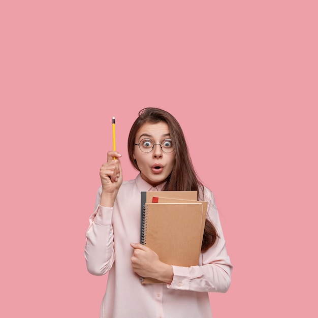 Young brunette student holding notebooks