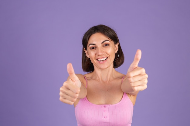 Young brunette in top isolated on purple wall