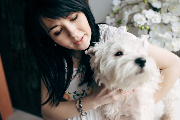 Young brunette with charming dog at home