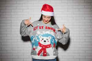 Free photo young brunette woman in christmas hat and sweater