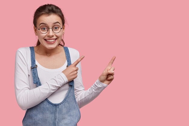 Young brunette woman in denim overalls