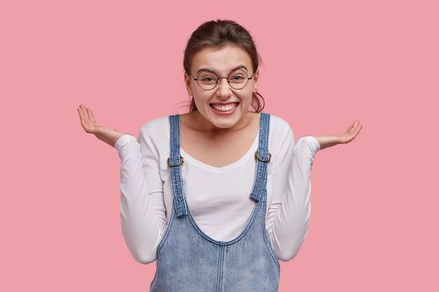 Free photo young brunette woman in denim overalls