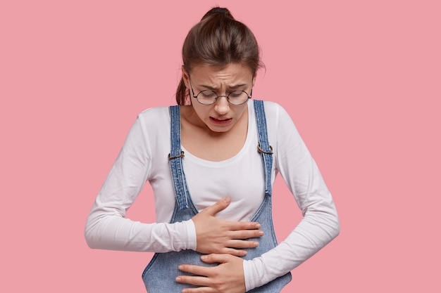 Young brunette woman in denim overalls