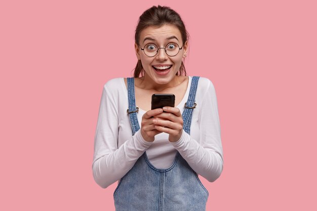 デニムオーバーオールを着た若い茶色の女性