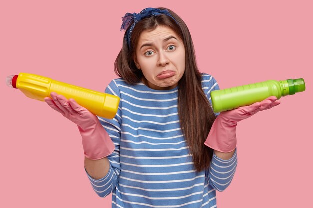 Young brunette woman holding cleaning products