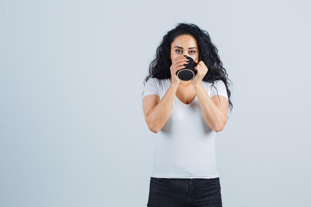 マグカップを保持している若いブルネットの女性