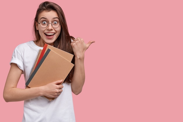 Young brunette woman holding notepads