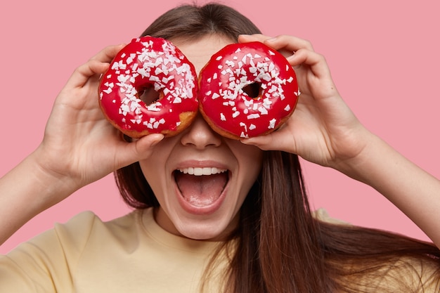 Young brunette woman holding tasty donuts