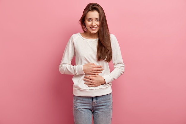 Free photo young brunette woman in jeans and sweater