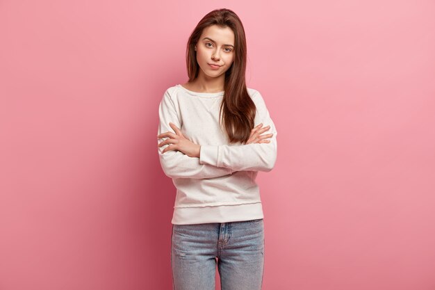 Молодая брюнетка женщина в джинсах и свитере