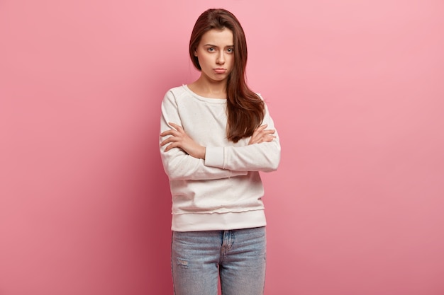 Молодая брюнетка женщина в джинсах и свитере