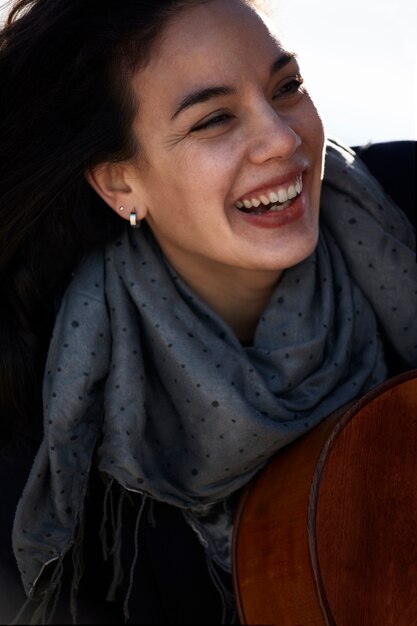 young brunette woman laughing with a scarf around her neck