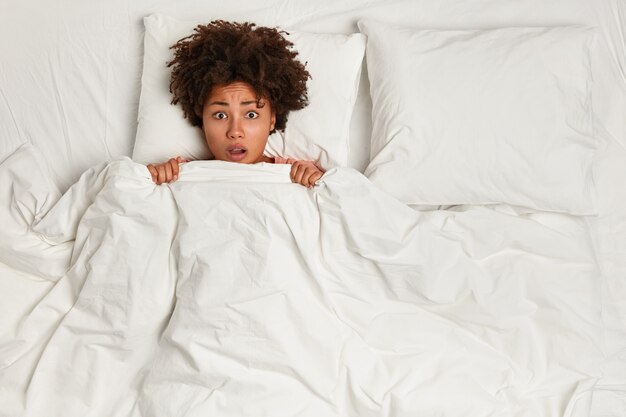 Young brunette woman lying in bed