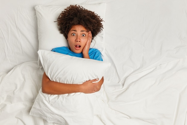 Free photo young brunette woman lying in bed