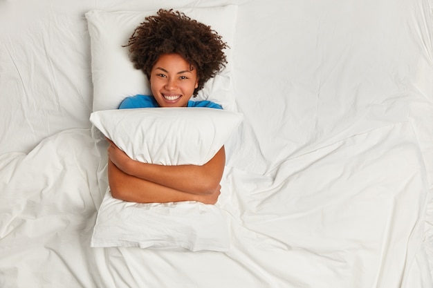 Бесплатное фото Молодая брюнетка женщина, лежа в постели