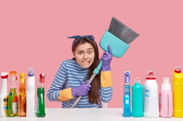 Young brunette woman sitting next to cleaning products