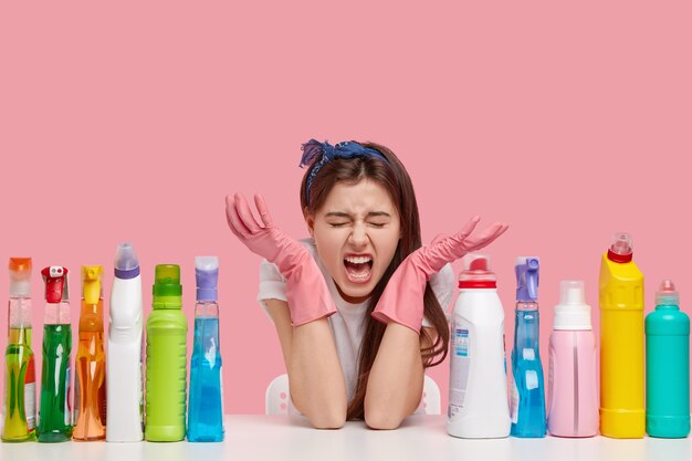 Young brunette woman sitting next to cleaning products