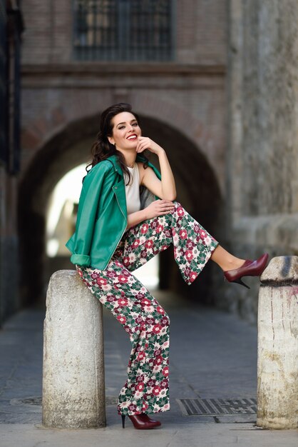 Young brunette woman smiling in urban background.