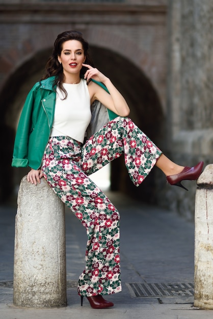 Free photo young brunette woman smiling in urban background.