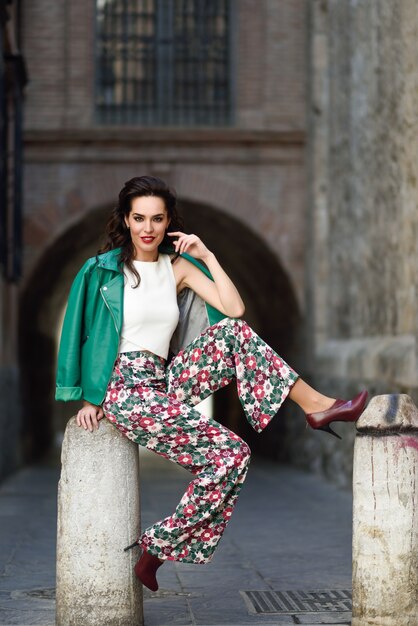 Young brunette woman smiling in urban background.