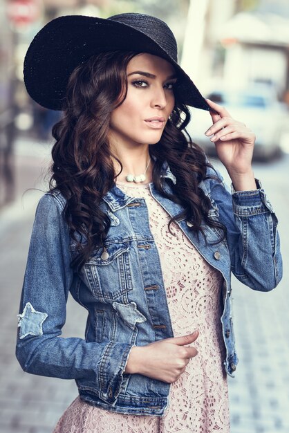 Young brunette woman standing in urban background.