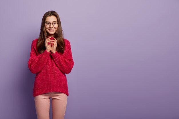 赤いセーターを着ている若いブルネットの女性