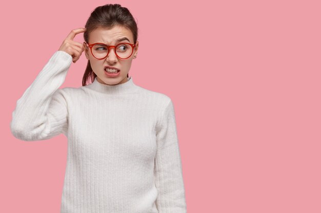 young brunette woman wearing white sweater and red glasses