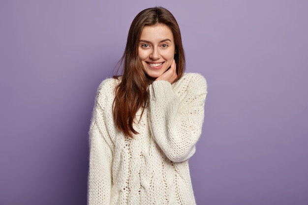 Young brunette woman wearing white sweater