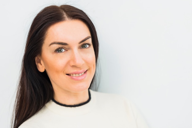 Young brunette woman in white smiling 