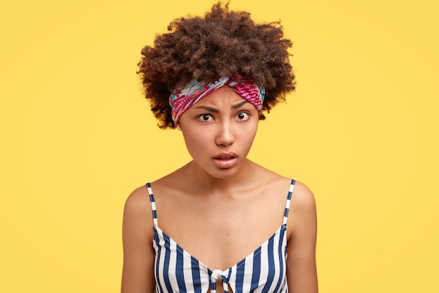 Free photo young brunette woman with curly hair and colorful bandana