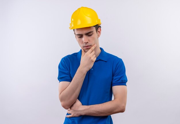 Молодой строитель человек в строительной форме и защитный шлем мышления