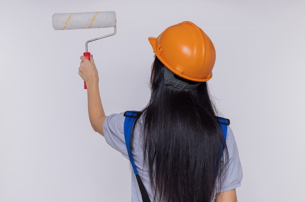 Young builder woman in construction uniform and safety helmet standing
