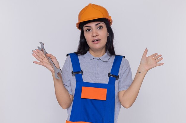 건설 유니폼과 안전 헬멧에 젊은 작성기 여자