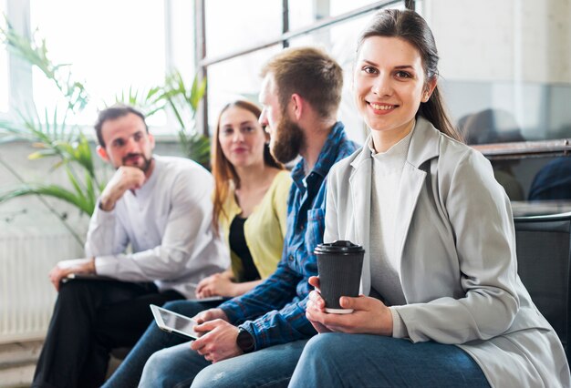 Foto gratuita i giovani colleghi di lavoro che si siedono insieme durante irrompono l'ufficio