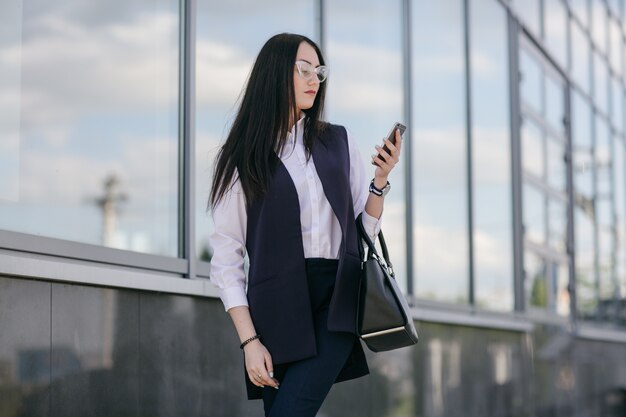 Young business girl looking at her smart phone